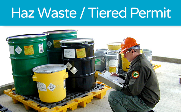 Worker inspecting hazardous waste containers for tiered permitting.