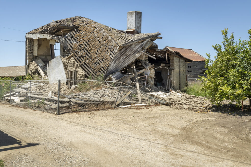 Collapsed building with exposed wooden beams and rubble