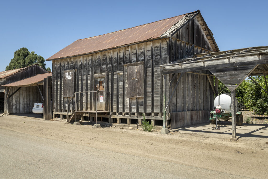 Historic wooden building structure with corrugated metal roof on a sunny day