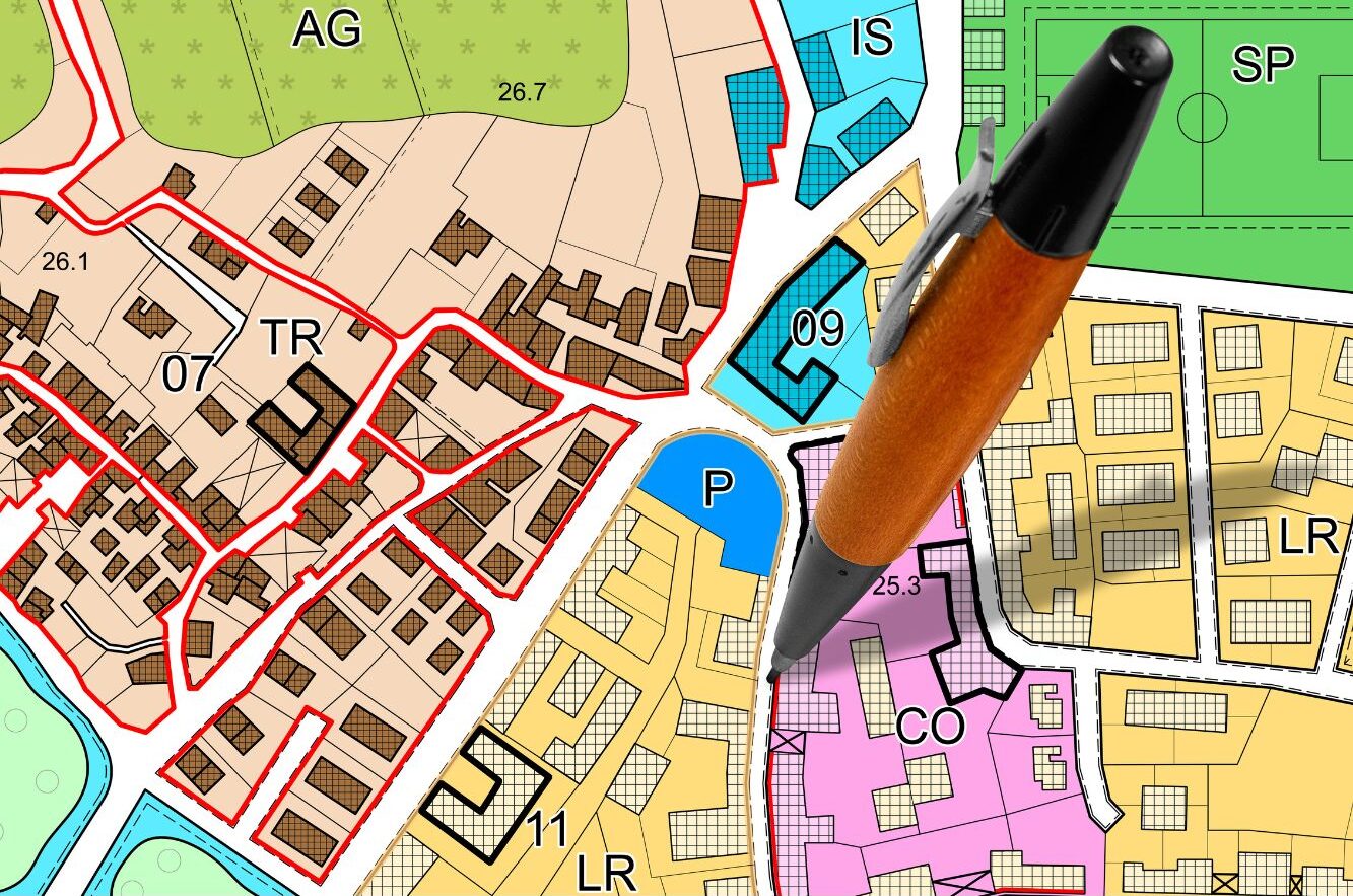 Colorful zoning map with a pen pointing at a designated area marked.