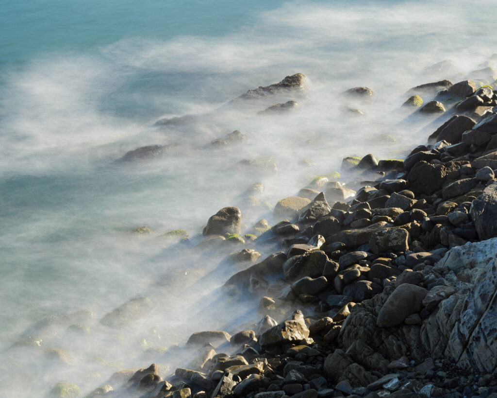 View of the Pacific Ocean at Point Mugu State Park, waves rolling over a rocky shoreline.