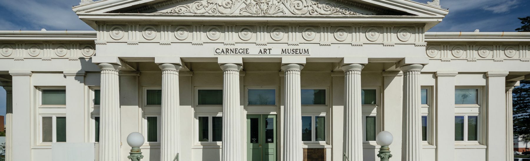 Front view of the Oxnard Carnegie Library façade featuring Doric columns and intricate architectural details.