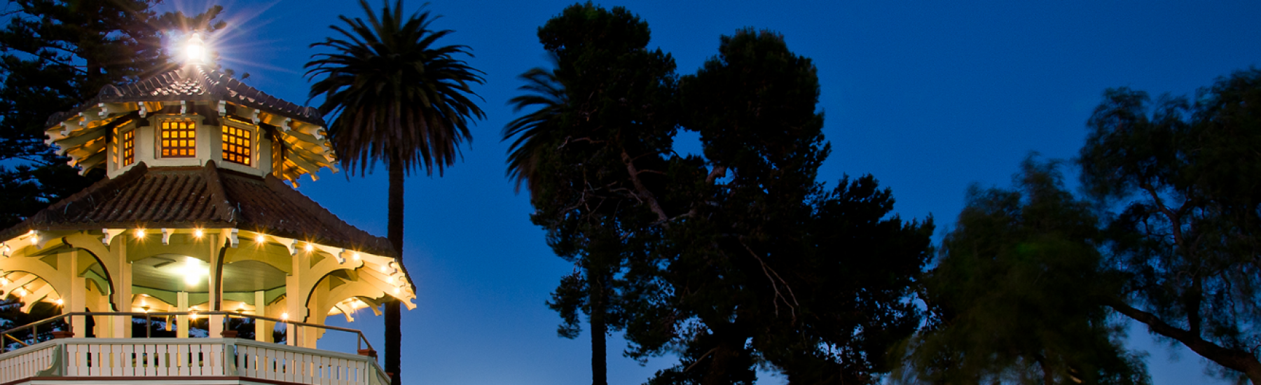 Illuminated pagoda at Oxnard Plaza Park, surrounded by nighttime scenery, with vibrant lights and colors