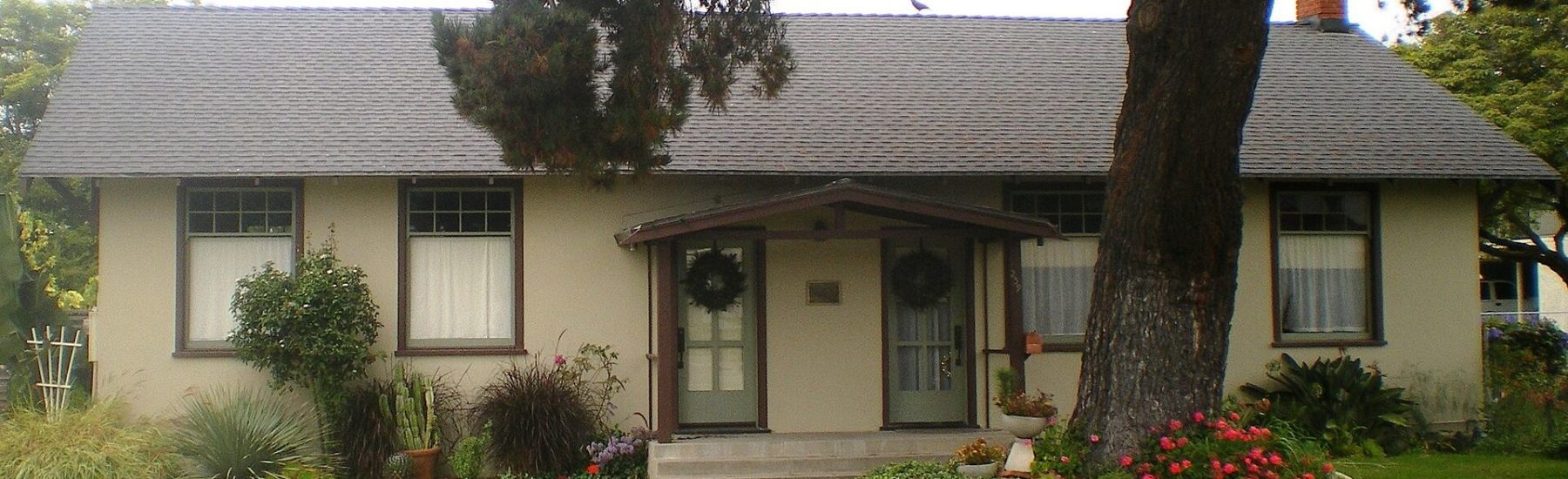 Exterior of the Port Hueneme Women's Improvement Club building with greenery in front