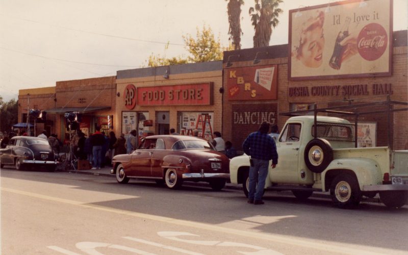 Vintage street scene with A&P Food Store, old cars, and Desha County Social Hall signage.